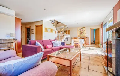 a living room with purple couches and a table at Stunning Home In Arenys De Munt in Arenys de Munt