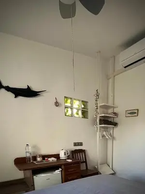 a bedroom with a bed and a desk and a shark on the wall at Sitges Garden Suite in Sitges