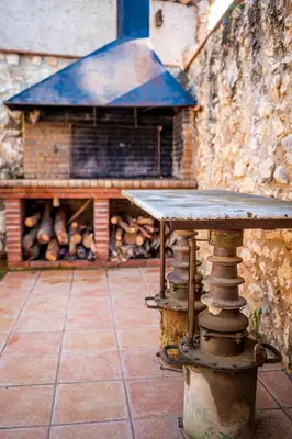 a table sitting in front of a brick building at La Masia in Sant Pau dʼOrdal