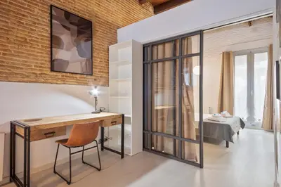 a home office with a desk and a bedroom at Alcam Gracia in Barcelona