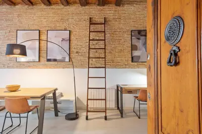 a ladder in a room with a table and chairs at Alcam Gracia in Barcelona