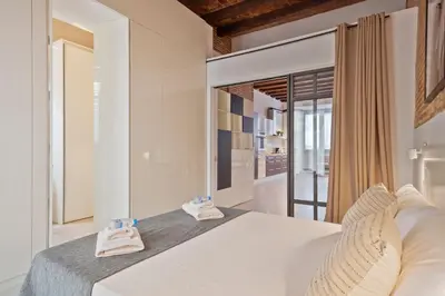 a bedroom with a white bed with towels on it at Alcam Gracia in Barcelona