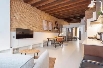 a living room and dining room with a brick wall at Alcam Gracia in Barcelona