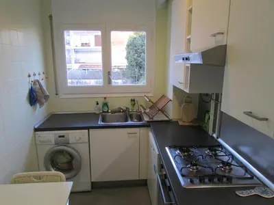 a kitchen with a stove and a sink and a washing machine at Acogedor apartamento en el centro de Sitges in Sitges