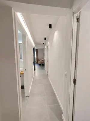 a hallway of a house with white walls and tile floors at Charming apartment Poblenou beach in Barcelona