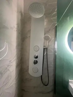 a shower with two shower heads in a bathroom at Atico 1º linea vistas Sitges in Sitges