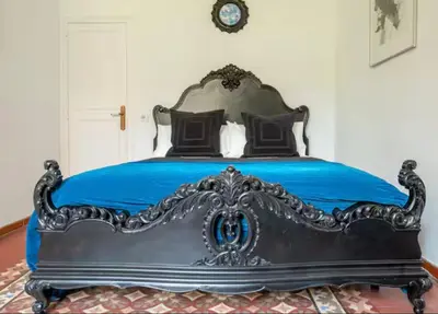 a bedroom with a bed with blue sheets and a clock at Céntrico y espacioso apartamento in Barcelona