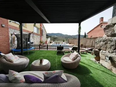 a patio with couches and chairs on the grass at Luxury Villa in Vallromanes - Mountain Views, Pool, Close to Barcelona and the Beach in Vallromanas