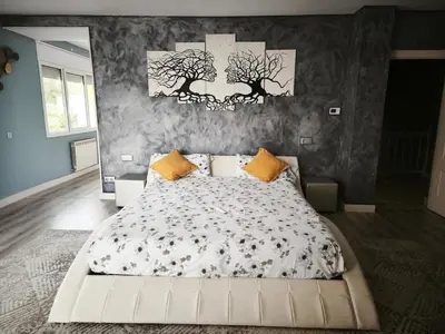 a bedroom with a large white bed with trees on the wall at Luxury Villa in Vallromanes - Mountain Views, Pool, Close to Barcelona and the Beach in Vallromanas
