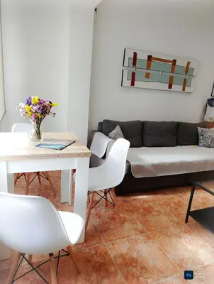 a living room with a couch and a table and chairs at Apartament in Pineda in Pineda de Mar