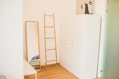 a white door with a ladder next to a mirror at Central apartment in Sant Antoni in Barcelona