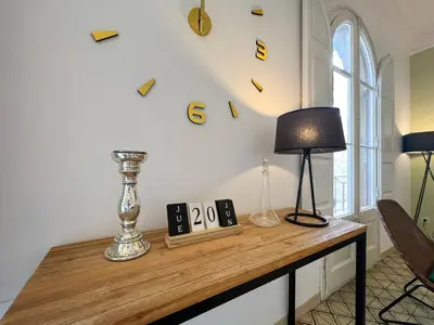 a table with a lamp and clocks on the wall at Stay U-nique Apartments Comte Urgell in Barcelona
