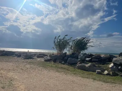 a beach with rocks and a person in the water at Apartamento Canet de Mar - Primera linea de Playa - Increibles vistas al Mar in Canet de Mar