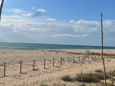 a fence in the sand on a beach at Apartamento Canet de Mar - Primera linea de Playa - Increibles vistas al Mar in Canet de Mar