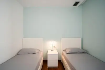 two beds in a room with white walls at Av d'Eduard Maristany, 13 in Sant Adria de Besos