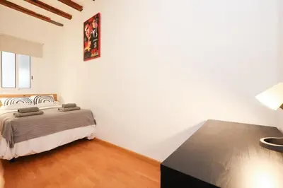 a bedroom with a bed and a table in it at La Rambla - Catalonia Square Apt 4BD-2BTH in Barcelona