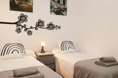 a bedroom with two beds and a sign on the wall at La Rambla - Catalonia Square Apt 4BD-2BTH in Barcelona