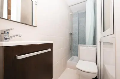 a bathroom with a toilet and a sink and a mirror at La Rambla - Catalonia Square Apt 4BD-2BTH in Barcelona