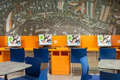 a classroom with orange and blue chairs and a chalkboard at Barcelona Pere Tarrés Youth Hostel in Barcelona