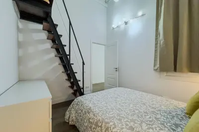 a bedroom with a bed and a spiral staircase at Precioso apartamento en Rambla Cataluña 35 in Barcelona