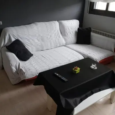 a white couch in a living room with a table at Apartamento Castellet1 in San Vicente de Castellet