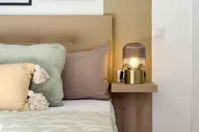 a lamp on a night stand next to a bed at Precioso apartamento en Ronda Sant Pau in Barcelona