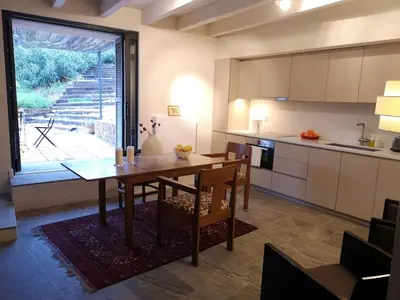 a kitchen with a wooden table and a dining room at Beautiful 15th century villa on 30 acre estate, for families only in Alella