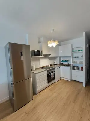 a kitchen with white cabinets and a stainless steel refrigerator at MM4-Apto en 1ª linea de playa in Mataró