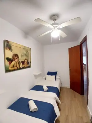 a bedroom with two beds and a ceiling fan at MM4-Apto en 1ª linea de playa in Mataró