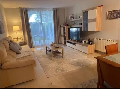 a living room with a couch and a tv at Surf&Snooze in Castelldefels