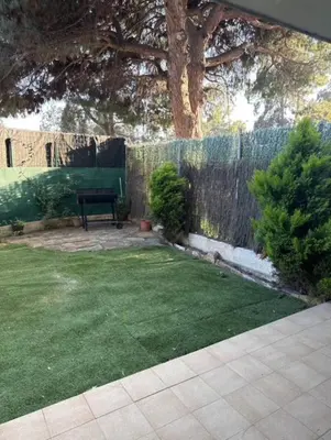 a garden with a bench and a fence at Surf&Snooze in Castelldefels