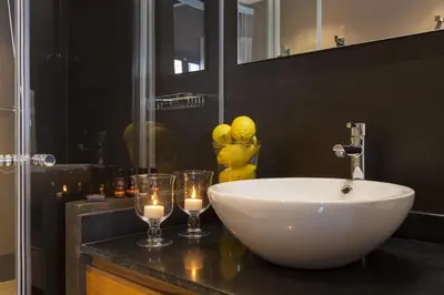 a bathroom with a white bowl sink and two glasses at Kare No Apartments by Sitges Group in Sitges