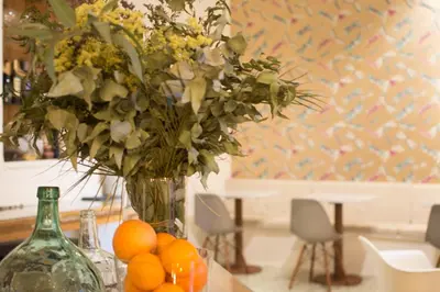 a vase with flowers and oranges on a table at Forget Me Not Barcelona in Barcelona