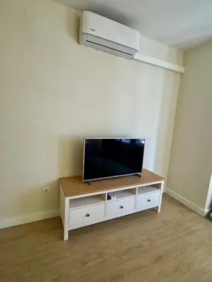 a living room with a flat screen tv on a cabinet at Loft Premium en Barcelona in Barcelona