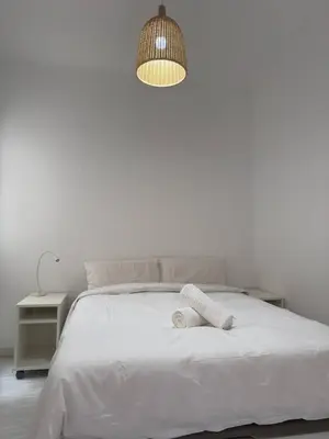 a bedroom with a white bed and a lamp at City Center 3 Bedroom Apartment! in Barcelona