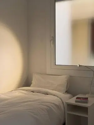 a bedroom with a bed and a table with a lamp at City Center 3 Bedroom Apartment! in Barcelona