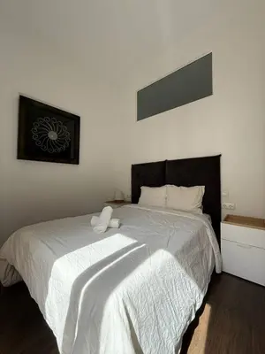 a bedroom with a large bed with white sheets at Centric 2 Bedroom Apartment in Barcelona