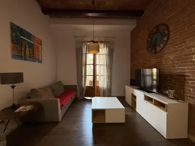 a living room with a couch and a tv at Centric 2 Bedroom Apartment in Barcelona
