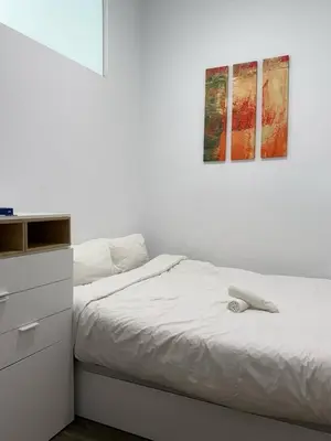 a bedroom with a bed and a painting on the wall at Centric 2 Bedroom Apartment in Barcelona