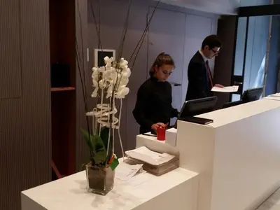 two people in an office with a desk with a computer at Hotel Àmbit Barcelona in Barcelona