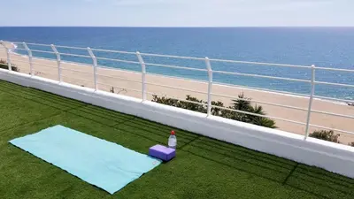 a balcony with a bottle of water and a beach at Exclusive Mediterranean Panorama in Sant Pol de Mar in San Pol de Mar