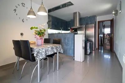 a kitchen with a table with chairs and a refrigerator at Bellavista in Argentona