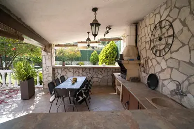 a kitchen with a table and a stone wall at Bellavista in Argentona