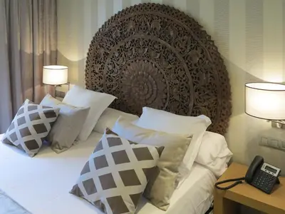 a bedroom with a bed with two lamps and a phone at Serennia Exclusive Rooms in Barcelona