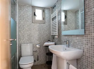 a bathroom with a white toilet and a sink at Aparthotel Bardon in Castelldefels