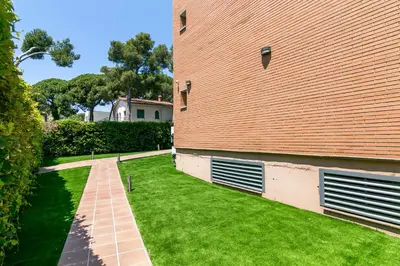a building with two garage doors on the side of it at Aparthotel Bardon in Castelldefels