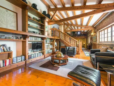 a living room with wooden ceilings and bookshelves at Cal Tomas in Castellet