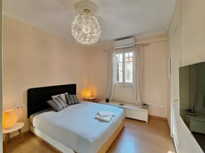 a bedroom with a large white bed and a chandelier at Elegant apartment Rambla Badal in Barcelona