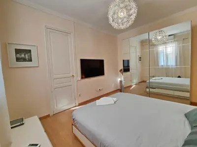 a bedroom with a large white bed and a television at Elegant apartment Rambla Badal in Barcelona
