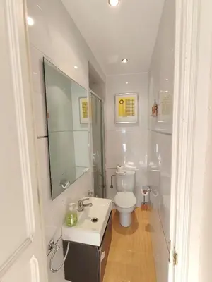 a white bathroom with a toilet and a sink at Elegant apartment Rambla Badal in Barcelona